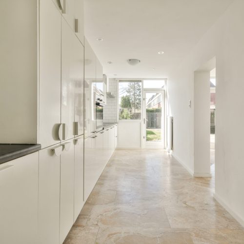 Spacious bright kitchen with white walls and tiled floor